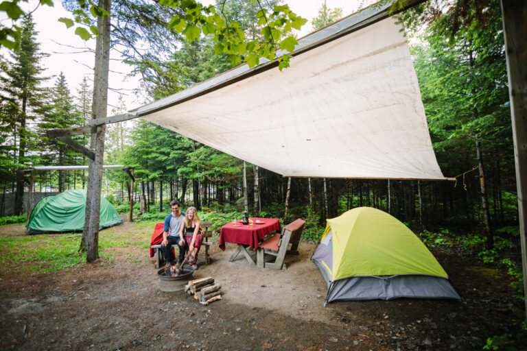 Un couple autour du feu sur un Site de camping avec abri chez Cime Aventure